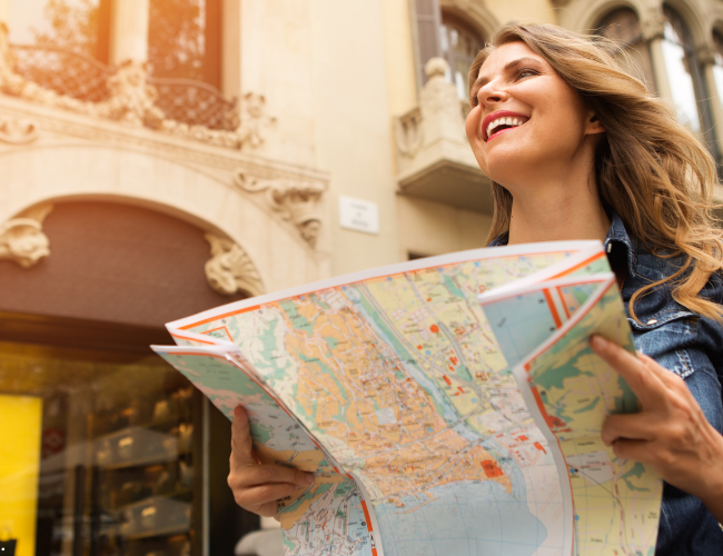 Woman planning her next adventure while looking at a map—reflecting excitement and exploration for travel deals.